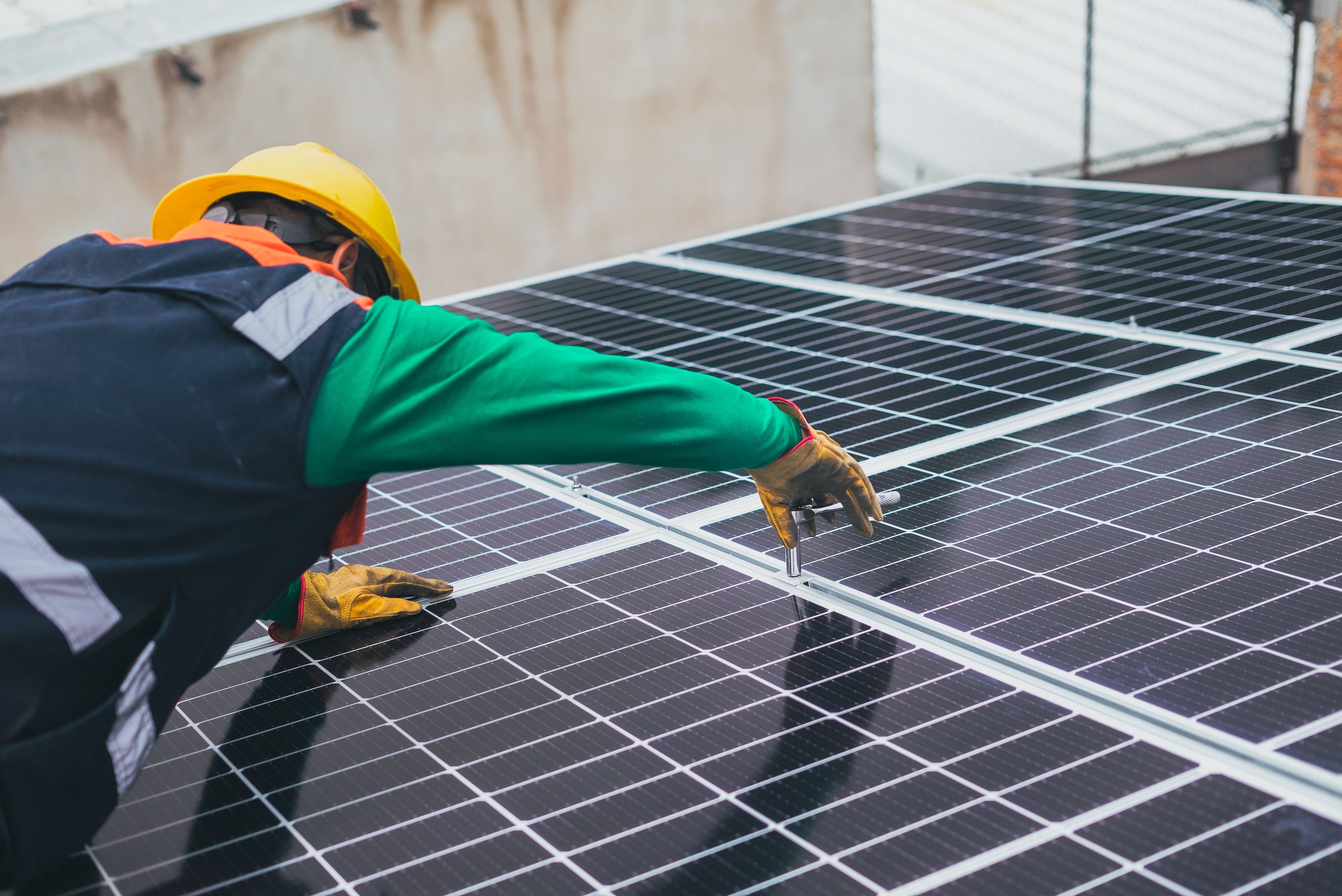 Solar technician securing photovoltaic panels during a rooftop installation